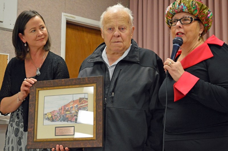 On Dec. 25, Town of Olds heritage advisor Michelle Jorgensen (left) and Mayor Judy Dahl presented longtime Christmas dinner organizer Henry Sonnenberg with a portrait of 50