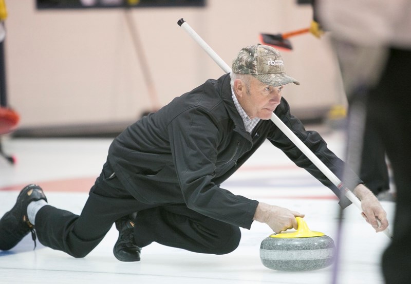 Frank Olson throws a rock during the Farmers and Farmerettes bonspiel at the Olds Curling Club.