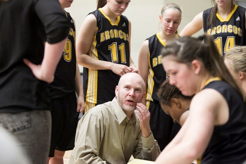 Olds College Broncos women&#8217;s coach Reg Carrick speaks with his team during a break in play at the Broncos&#8217; game against Briercrest College.