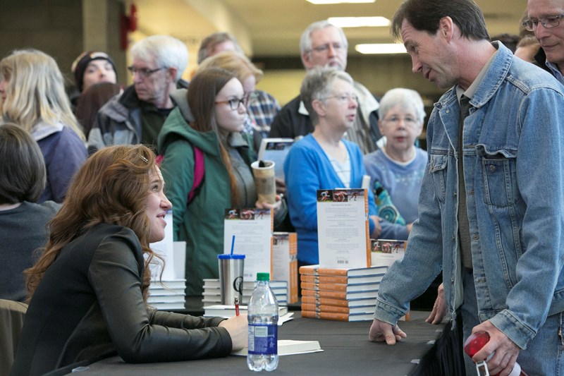 Clara Hughes signs a copy of her book for Terry Stirton after giving her presentation at the Ralph Klein Centre on March 9.