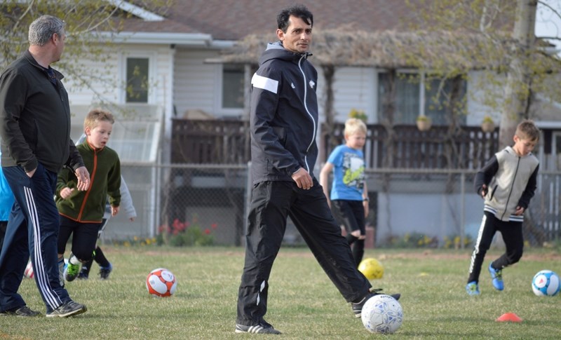 Broncos soccer coach Macky Singh leads practice for U-10 players at Deer Meadow School.