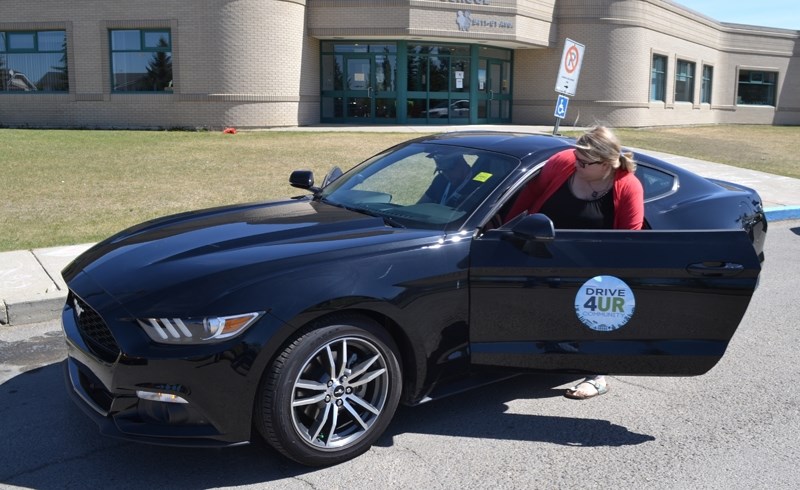 Kayla Ferguson gets ready to test drive a 2016 Mustang with Cam Clark Ford employee Brendan Fink.