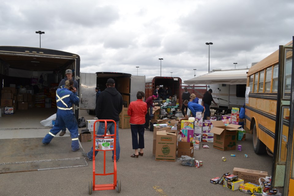 Volunteers sort donations and trailers stand by ready to take them in the southeast corner of the Olds Walmart parking lot. Olds resident Jordon Rhude, who started it all on