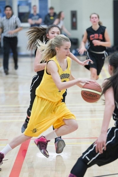 U-15 Calgary Warriors player Brooklyn Baker tries to get past the guard of a Cobras player.