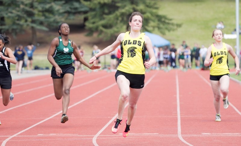 Olds High School student Laura Klinck crosses the finish line in the intermediate girls 100-metre dash. Klinck got first place in the 100, 200-metre, long jump and triple