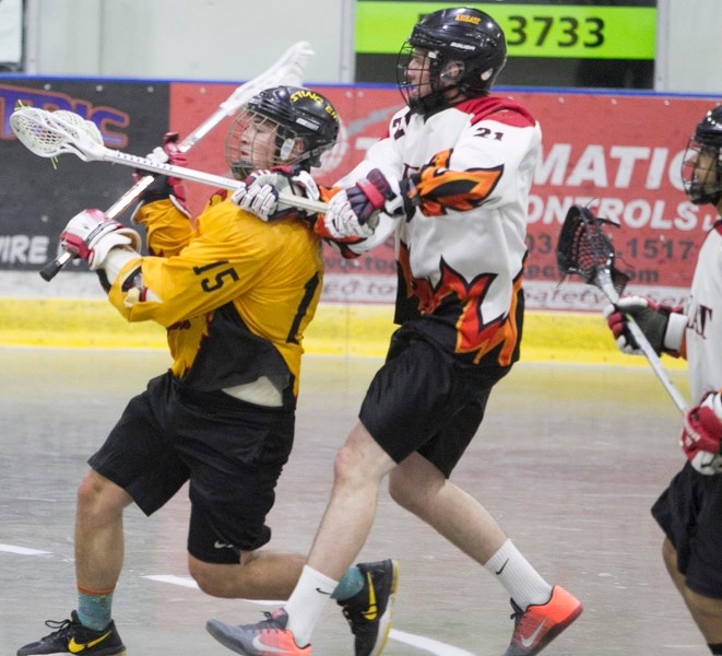 Olds junior Stingers player Everest Hughes gets checked by a High River Heat player during the teams&#8217; game at the Olds Sportsplex on June 3. The Heat won the game 8-6.