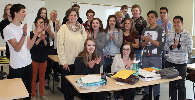 Students applaud Olds High School teacher Angie Dezall, who has received an Excellence in Teaching award.