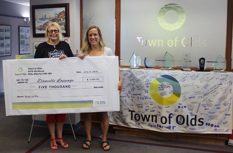 From left, Olds mayor Judy Dahl presents wrestler Danielle Lappage with a $5,000 cheque. The town had pledged to match online fundraising efforts for the local Olympian