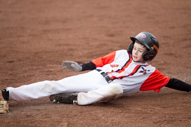 The Olds Spitfires&#8217; Bryson Luft slides back into third base after attempting to score during the Baseball Alberta Pee Wee AA Tier II Provincial Championship at O.R.