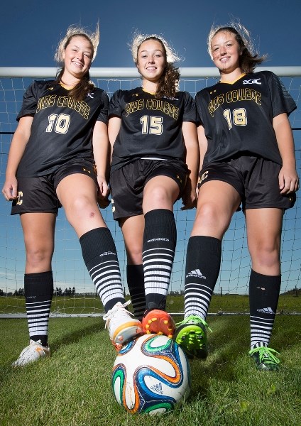 From left, sisters Jessie, Jasmine and Jamie Flett, who all play for the Olds College Broncos soccer team.