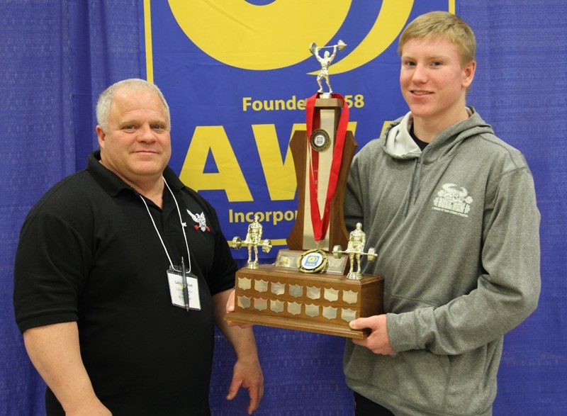 Zachary Latimer poses with his trophy, alongside coach Brent Garrett.