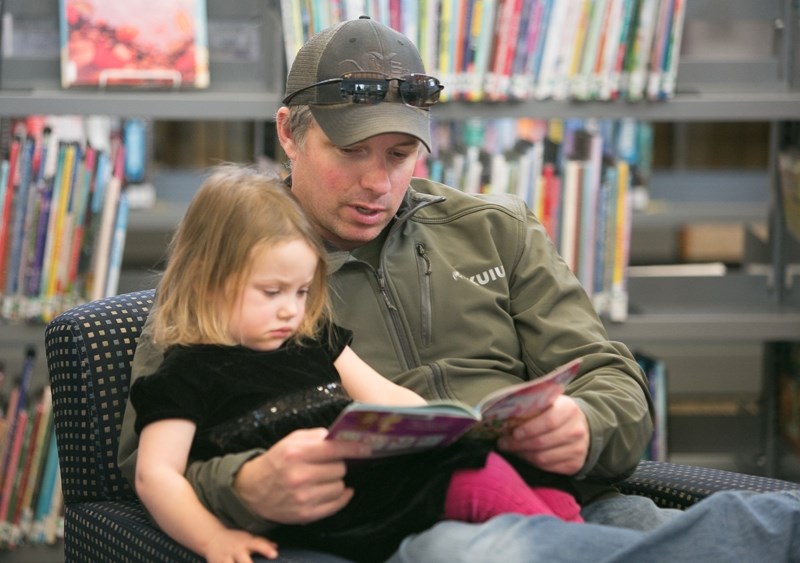 Lindsay McQuaid reads to daughter Jayden during Literacy Day.