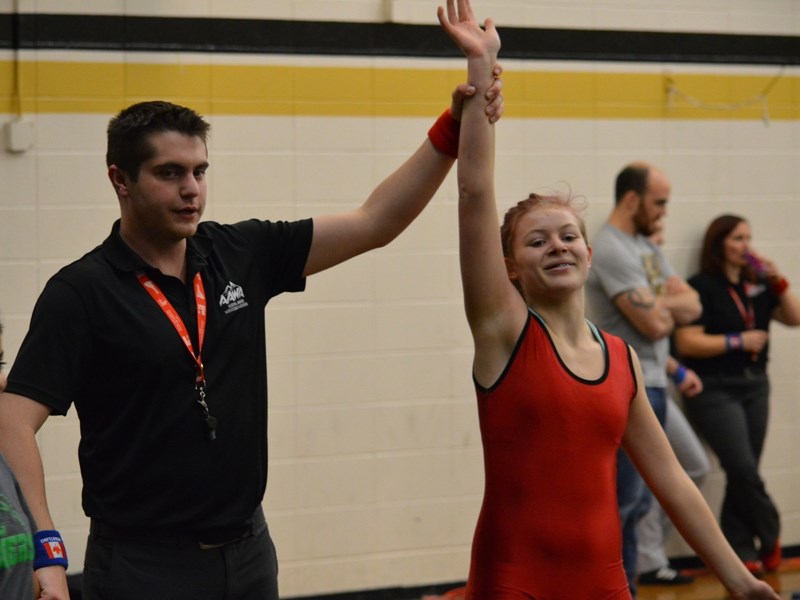 A referee holds up the hand of a victorious Bella Cranston.