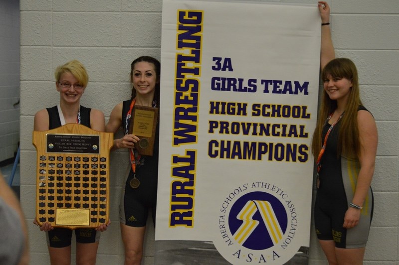 Esther Koelstra, McKensie Hammer and Isabelle Schaber pose with the 3A girls provincial wrestling championship banner, trophy and plaque they won in Edson.