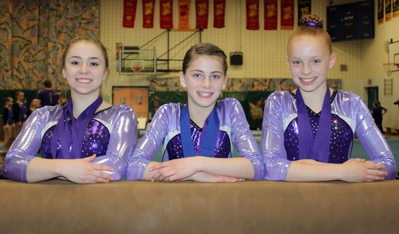 Jennifer Conway, left, Chloe Gardner, centre, and Soulayah Petersen, right, will become the first gymnasts ever to represent the Olds Gymnastics Club at the provincial