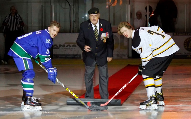 Longtime Grizzlys volunteer Ken Johnston makes the ceremonial puck drop at last year&#8217;s Remembrance Day game. Johnston was a timekeeper and known for passing out pieces