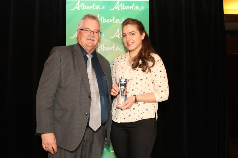 Olds library computer services coordinator Ceima Kemaldean, right, receives the Ministerial Excellence award from deputy municipal affairs minister Brad Pickering.