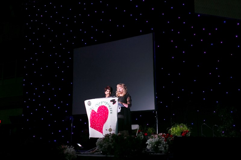 Raelynn Notley, left, looks on as Gloria Ulry gives a tribute to Dot Negropontes.