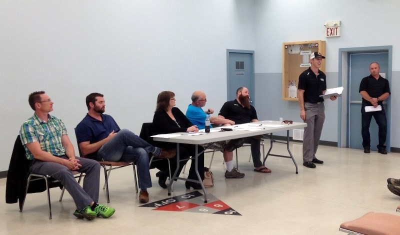 Board members of the Olds Sportsmen&#8217;s Recreational Association look on as Jason Jaffray, second from right, and Mike van Tetering, far right, present details about the