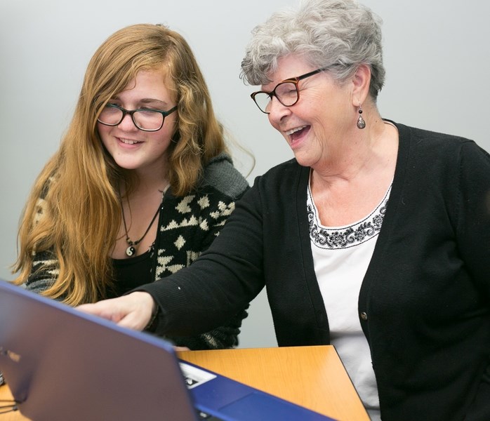 Abby-Jean Gertridge works with Dorothy Christensen during a Cyber Seniors session at the Olds Municipal Library.