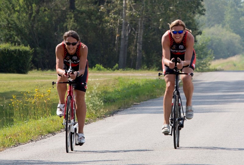 Triathletes Leoni Kelly, left, and Hillie Van&#8217;t Klooster ride along Twp Rd. 324.