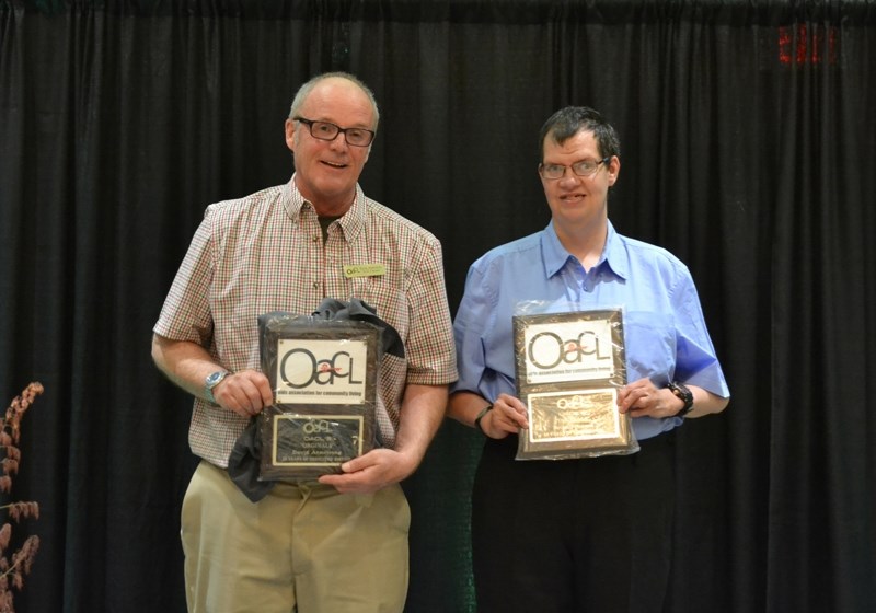 Olds Association for Community Living staff member David Armstrong, left, and client Brian Johnson received awards for being involved with the OACL throughout its 25-year