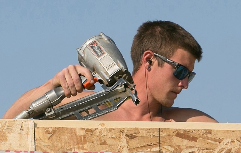 A framer works on a duplex for Habitat for Humanity in Olds.