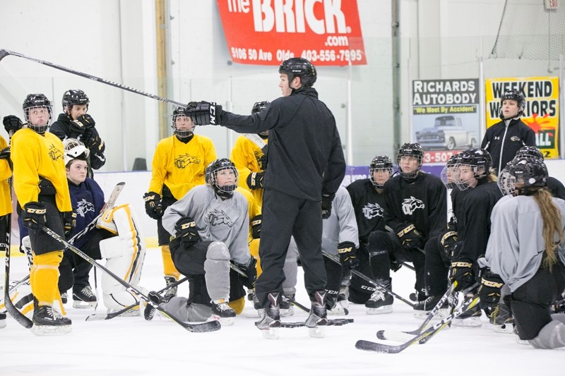 Olds College Broncos women&#8217;s hockey head coach Chris Leeming speaks with members of the team during a practice at the Olds Sportsplex.