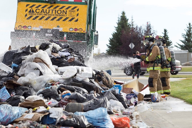 Olds firefighters work to extinguish a fire in a garbage truck on 65 Avenue on Sept. 27.