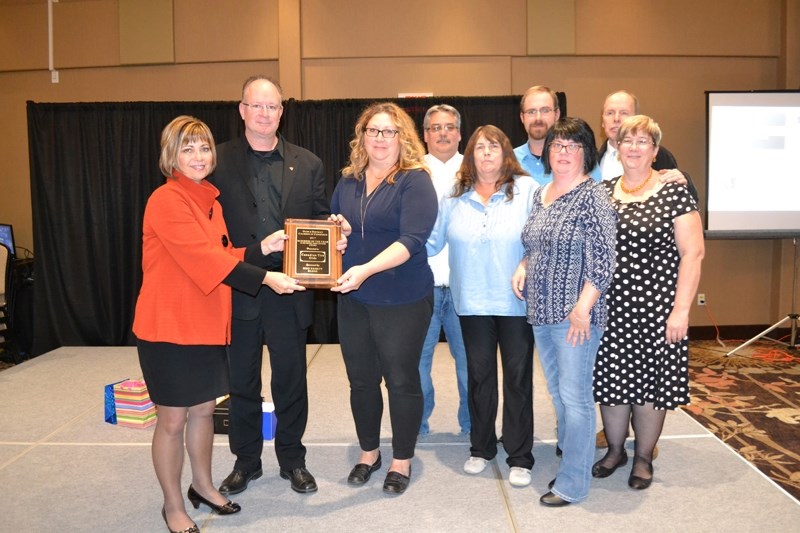 Canadian Tire staff pose with the Business of the Year award for firms with 16 employees or more, presented by Debbie Packer of sponsor BMO Nesbitt Burns (far left).&lt;br