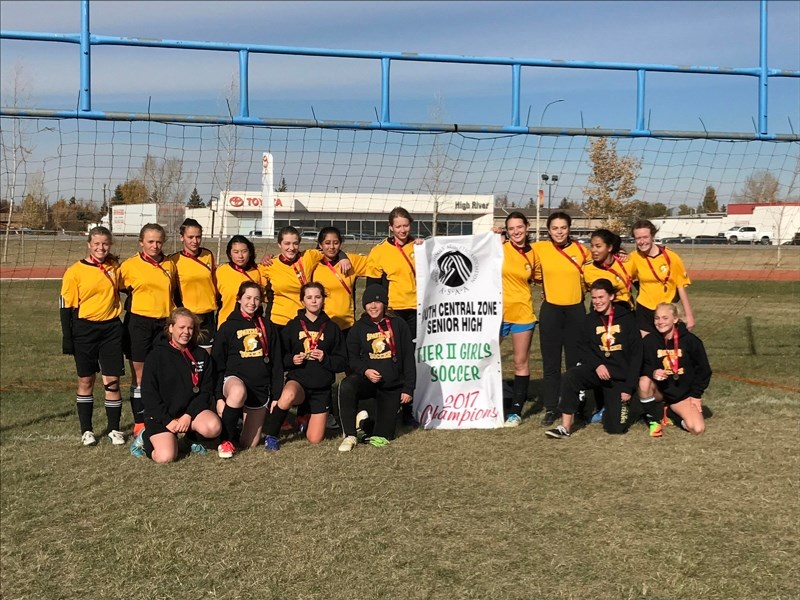 Members of the Olds High School Spartans girls soccer team proudly pose with their Zone II championship banner after shutting out every team they faced during the