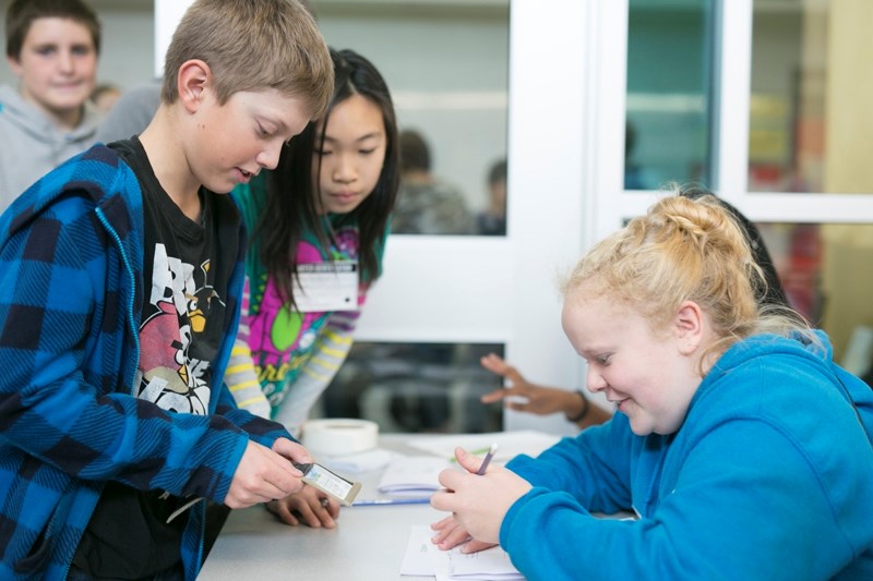 Holy Trinity Catholic School Grade 7 student Colin Chant, left, checks in with deputy returning officer Grade 6 student Nadine Jorgenson during a mock election at the school .