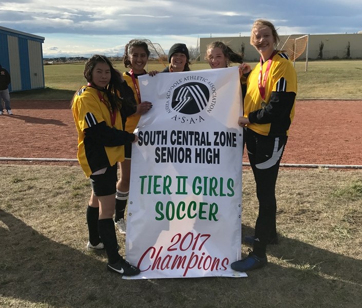 Members of the Olds High School girls soccer team display the banner they received after winning the 2017 Tier II Girls soccer chalmpionship. From left: Rose Chong-Wu, Humera 