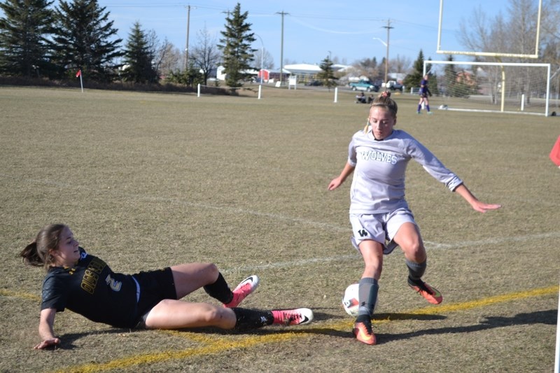 SLIDER &#8211; Fullback Meg Rogers makes a sliding effort for possession of the ball against a Grande Prairie Wolves player during the ACAC Women&#8217;s Soccer Championship