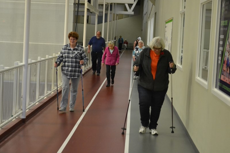 Members of the walking group proceed along the indoor track in the Community Learning Campus.