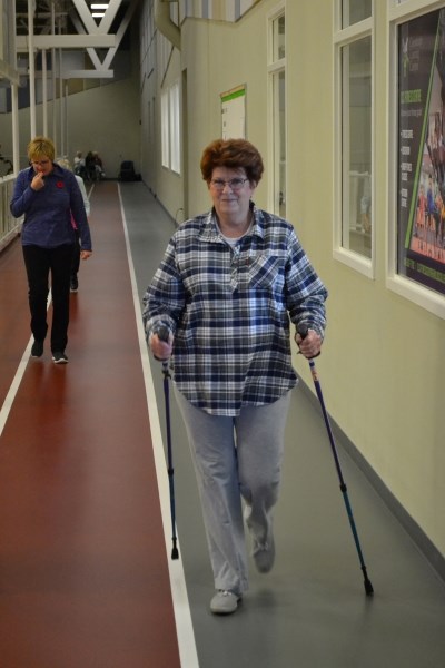 Welmoet Bols, a member of the walking group, cracks a bit of a smile as she confidently makes a turn along the indoor track.