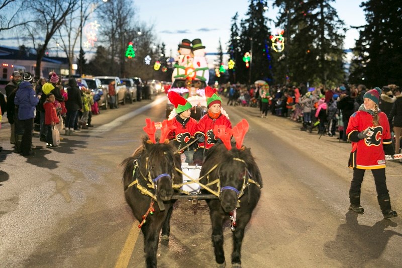 Participants make their way along the parade route in a wagon during the Olds Fashioned Christmas Light Up event.