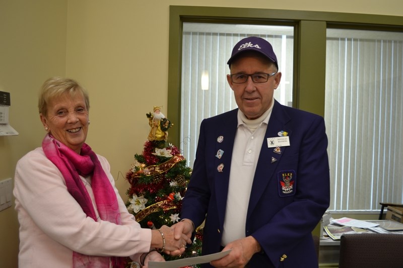 Erica Sweetman, a director with Olds and District Christmas Angels Society accepts a $500 donation to the society from Doug Manning, president of Olds Elks Lodge #100 on