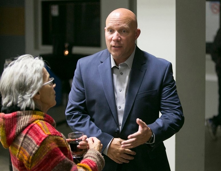 Mayor Mike Muzychka, seen here talking to a local resident, says several businesses, including a third marijuana production facilty, are looking at locating in Olds in the