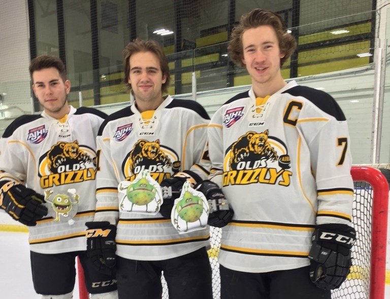 Parker Ward, Jeremy Klessens and captain Chase Olsen of the Olds Grizzlys pose with reminders to get your flu shot.