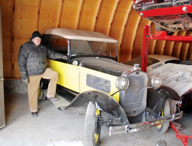 Jack Anderson leans against one of his vintage cars.