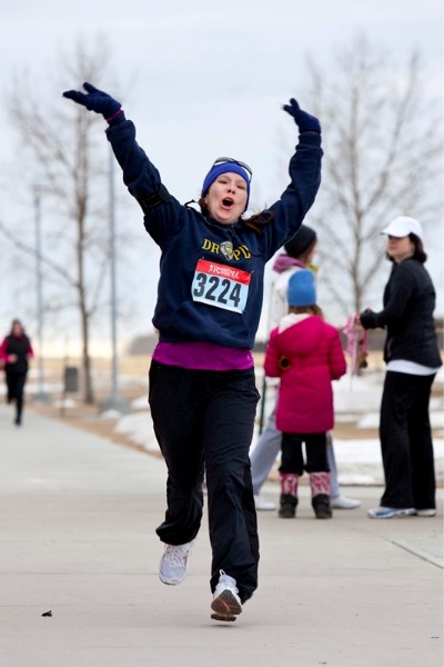 Kari Bakelaar of Carstairs celebrates as she crosses the finish line of a 5 kilometre run held outside the CLC last Sunday.