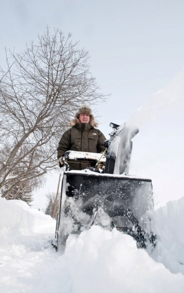 Todd Martin clears his sidewalk Tuesday morning after the night&#8217;s heavy snowfall.