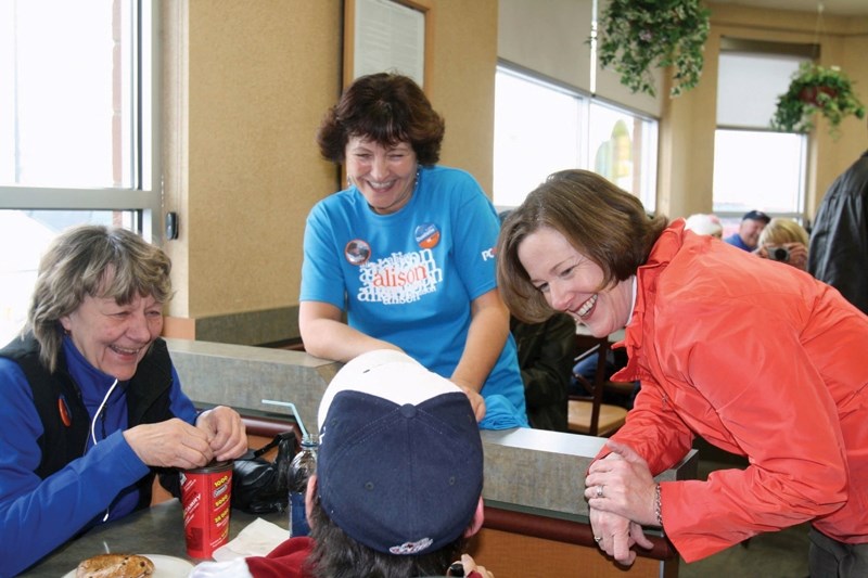 Redford talks with Linda and Trevor Pare Monday during a campaign stop at Tim&#8217;s in Innisfail.