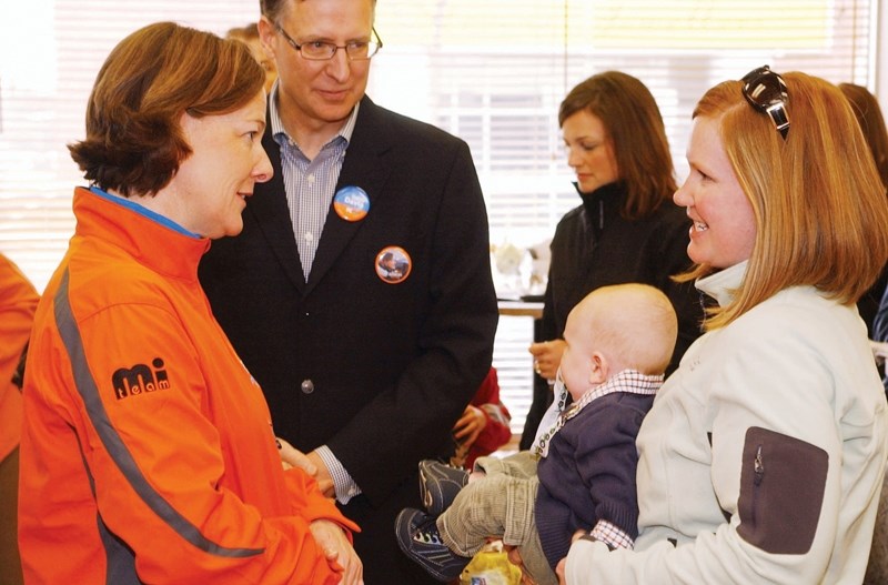 Premier Alison Redford chats with Joy Cavin and baby Liam Calvin, with Olds-Didsbury-Three Hills constituency PC candidate Darcy Davis in the background. Premier Redford was