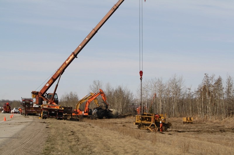 Crews work on cleaning up a train derailment just off the QEII Highway north of the Bowden Institution Saturday morning.