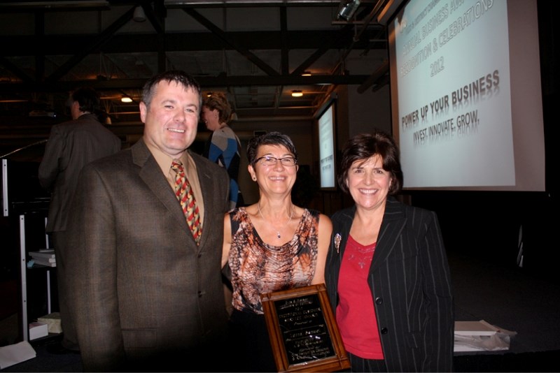 Dan Daley and Charlotte Hogarth, Olds Institute for Community &amp; Regional Development representatives, flank A&amp;W employee Lorna Samuel after Samuel won the 2012