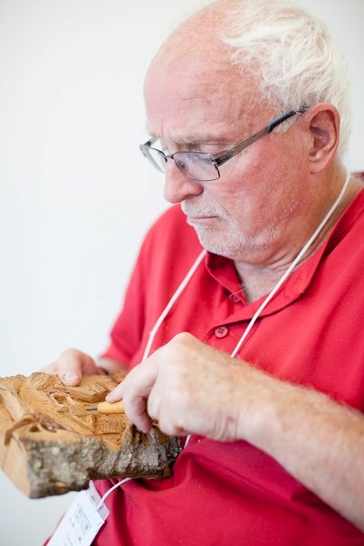 Donald James works on a piece of black poplar bark as part of a bark carving relief class during Olds College&#8217;s Hort Week on campus on July 25.