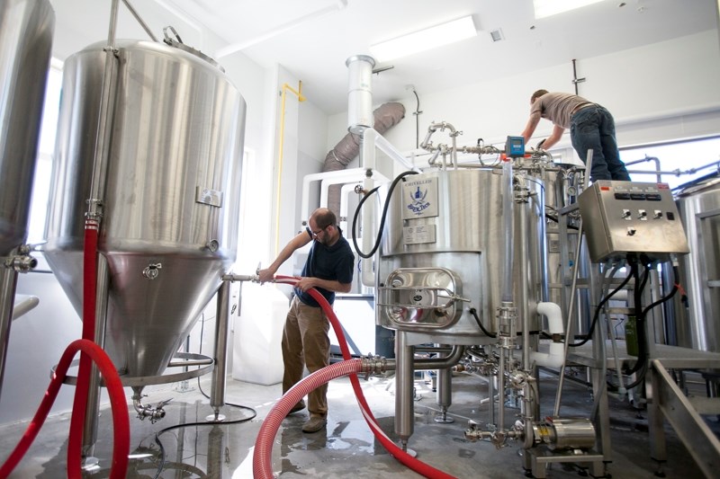 Olds College professor Jordan Ramey, left, and brewmaster Duncan Britton get the school&#8217;s new brewery equipment ready for the first batch of beer on Aug. 22.