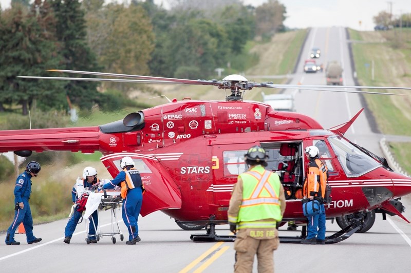 A STARS air ambulance crew loads a 71-year-old local woman injured in a crash west of Olds on the afternoon of Sept. 18 into a helicopter. The woman did not survive her